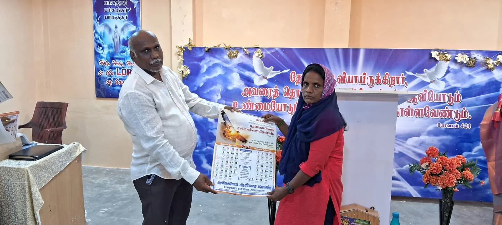 An adult participant receiving an item at a Puducherry community programme